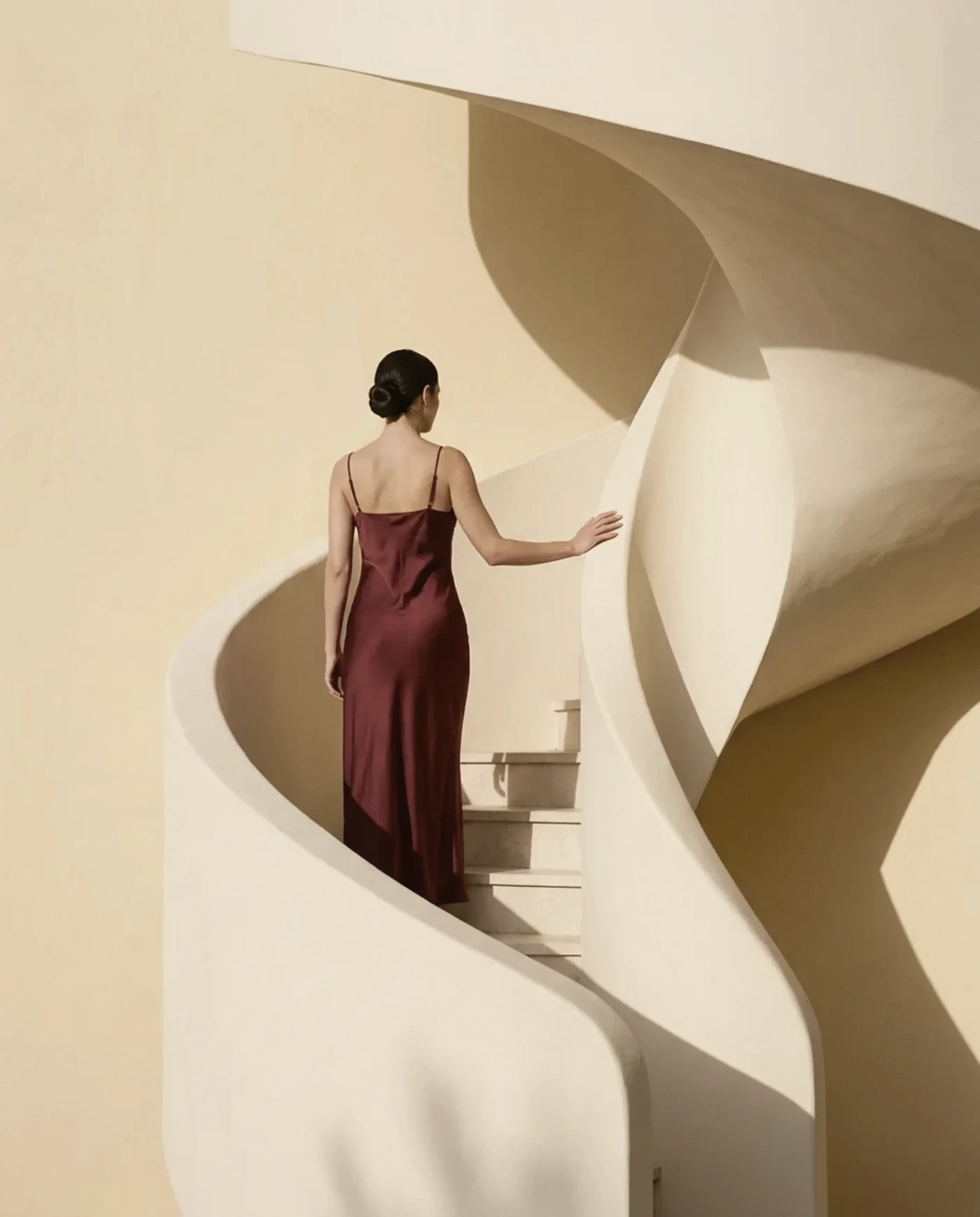 A woman in a red dress climbing a sculptural staircase